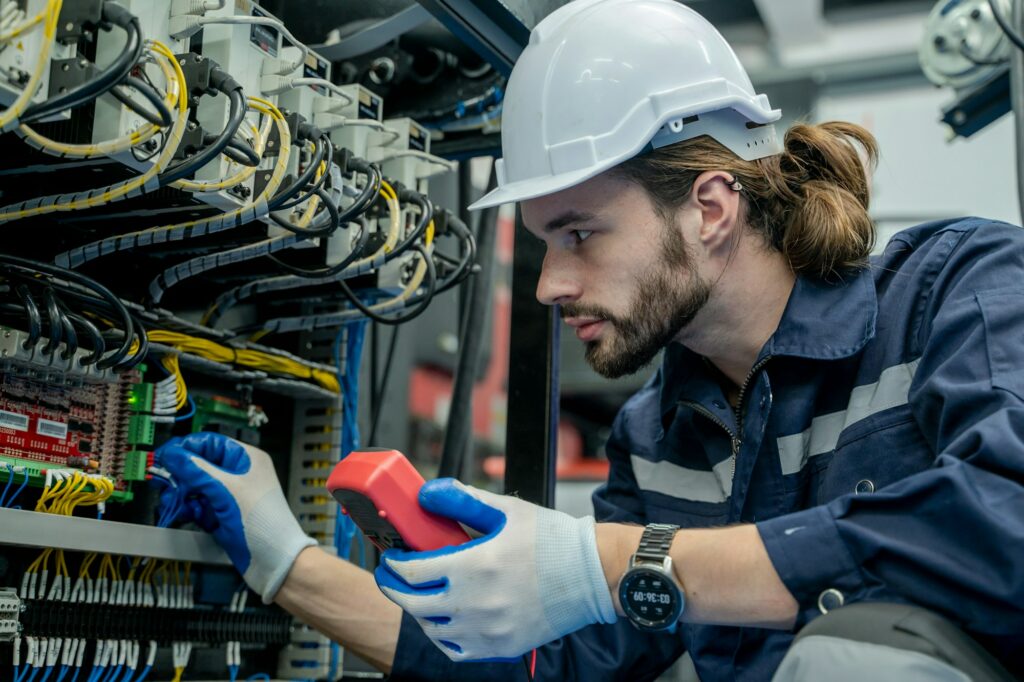 Electrical engineers using measuring them with a multimeter test electrical installations.