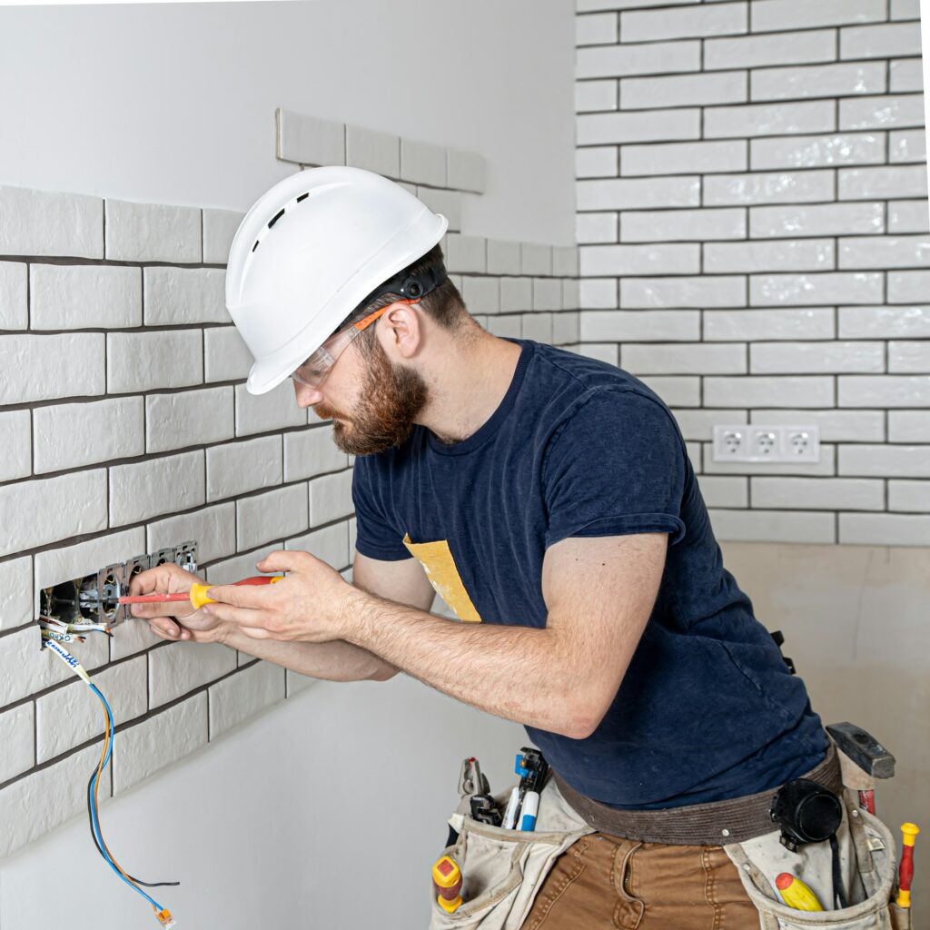 Electrician Builder at work, installation of sockets and switches.