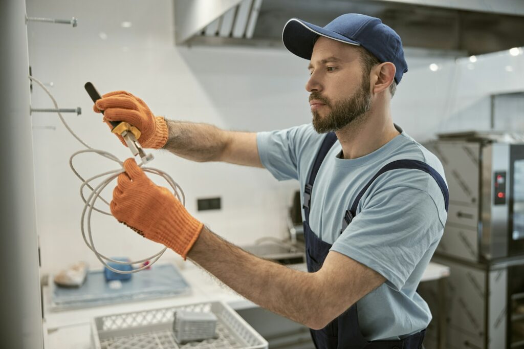 Male electrician repairing electric cable with pliers