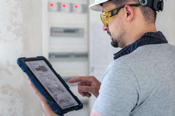 Man, an electrical technician working in a switchboard with fuses. Installation and connection of electrical equipment.